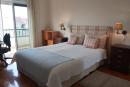 Quarto com cama dupla, secretária, armários embutidos e varanda