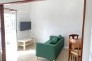 Sala com sofá, TV e zona de refeições