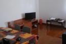 sala ampla com sofás, mesa, cadeiras e televisão