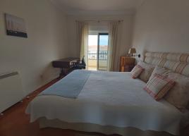 Quarto com cama dupla, secretária, armários embutidos e varanda