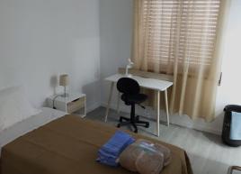 Quarto individual com casa de banho privativa e guarda roupas integrado.