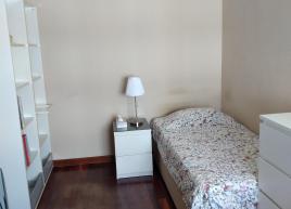 Um quarto, com cómoda, secretária e cadeira e roupeiro