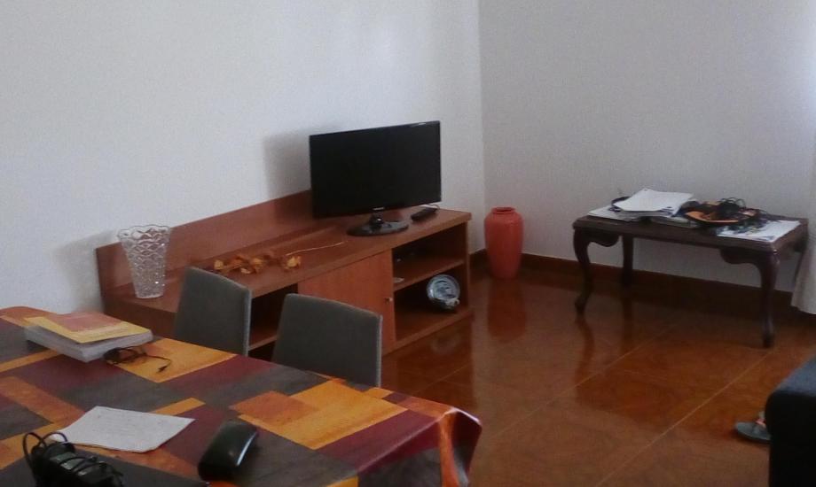 sala ampla com sofás, mesa, cadeiras e televisão